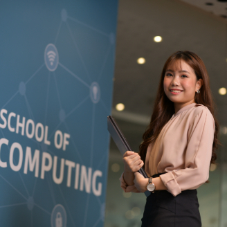 SOC-SOC Landing Student Taking Picture with wall that says School of Computing-v01